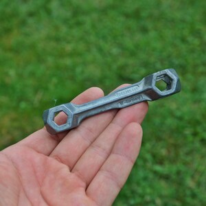 K&ouml;nnte beinhalten: Ein silberner Schraubenschl&uuml;ssel mit zwei sechseckigen &Ouml;ffnungen. Der Schraubenschl&uuml;ssel ist mit "Made in W-Germany" beschriftet.