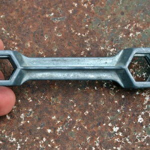 K&ouml;nnte beinhalten: Ein silberner Schraubenschl&uuml;ssel mit zwei sechseckigen &Ouml;ffnungen. Der Schraubenschl&uuml;ssel ist aus Metall und hat eine glatte Oberfl&auml;che.