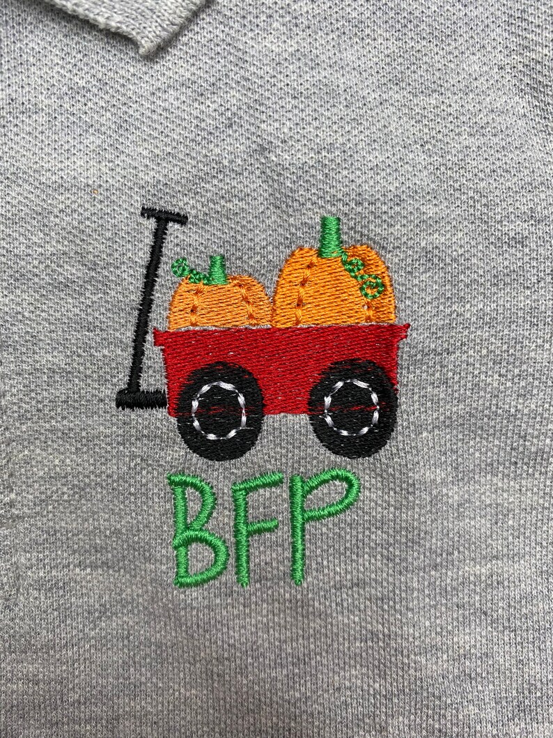 Puede incluir: Una sudadera gris con un dise&ntilde;o bordado de un carro rojo que lleva dos calabazas naranjas. El texto "BFF" est&aacute; bordado debajo del carro en verde.
