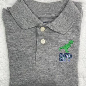 May include: Gray polo shirt with a green dinosaur and blue embroidered letters that spell "BFP".