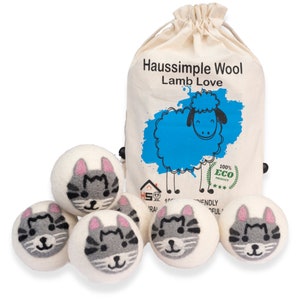 May include: Six white wool dryer balls with a gray cat face design. The balls are in a white drawstring bag with the text "Haussimple Wool Lamb Love" and a blue cartoon sheep. The bag also has a label that says "100% Eco Product" with three stars.