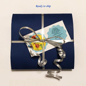 Navy blue gift sleeve wrapped with a silver ribbon and bow, including thank you message, which shows the packaging is ready to ship.