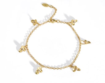 May include: A gold-toned chain bracelet featuring five evenly spaced, three-petaled flower charms. Each flower charm is accented with a small, centered purple gemstone. The bracelet includes a lobster claw clasp and an adjustable extender chain.