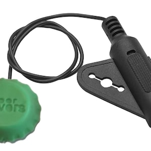 May include: A black and green beer saver with a black cord and a 1/4 inch jack. The beer saver has the words "beer saver" printed on it.