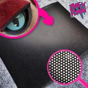 Op de afbeelding: Zwart geperforeerd materiaal met een close-up van een turquoise en zwart oog, en een vergrootglas met een wit en zwart stippenpatroon. Het logo "Fluffy Demon" staat in de rechterbovenhoek.