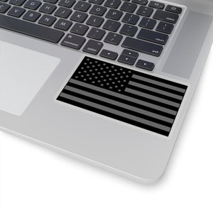 May include: A black and white American flag sticker on a silver laptop.