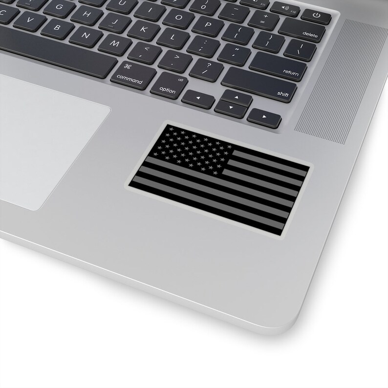 May include: A black and white American flag sticker on a silver laptop.