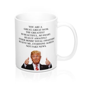 May include: White ceramic coffee mug featuring a black and white image of Donald Trump giving a thumbs up. The text on the mug reads: "You are a great, great mom. The greatest! So beautiful, so smart. Really amazing! Other moms? Total disasters! Believe me. Everyone agrees. Not fake news."