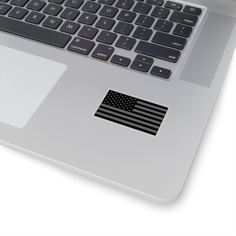 May include: A black and white American flag sticker on a silver laptop.