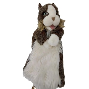 May include: A plush hand puppet in the shape of a dog. The puppet has a brown and white fur body, with a white face and chest. The dog's mouth is open, revealing a pink tongue. The puppet is designed to be worn on the hand.