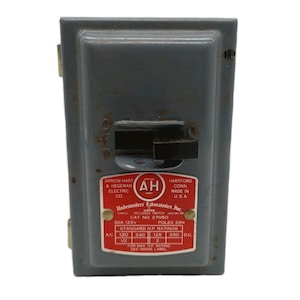 May include: A vintage grey electrical switch box with a black lever and a red label. The label includes text from Arrow-Hart & Hegeman Electric Co. and Underwriters Laboratories, Inc. The switch is marked "Off" and "On".