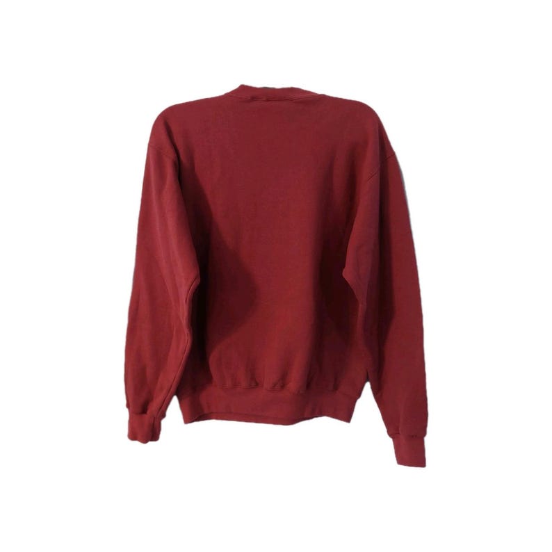 May include: A maroon-colored sweatshirt with long sleeves. The crew neck sweatshirt is made of a soft material. The cuffs and hem are ribbed. The back of the sweatshirt is visible.