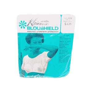 Puede incluir: Un paquete vintage de Bloushield de Kleinert, protección para las axilas. El embalaje es blanco y turquesa, con una ilustración retro de una mujer. El texto incluye "2421 WHITE SIZE 44 Regular Shape".