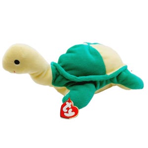 以下が含まれることがあります： クリーム色の頭と手足、緑とクリーム色の甲羅を持つぬいぐるみカメ。カメには赤いハート型のタグが付いています。このおもちゃは柔らかく、抱きしめたくなるように設計されています。