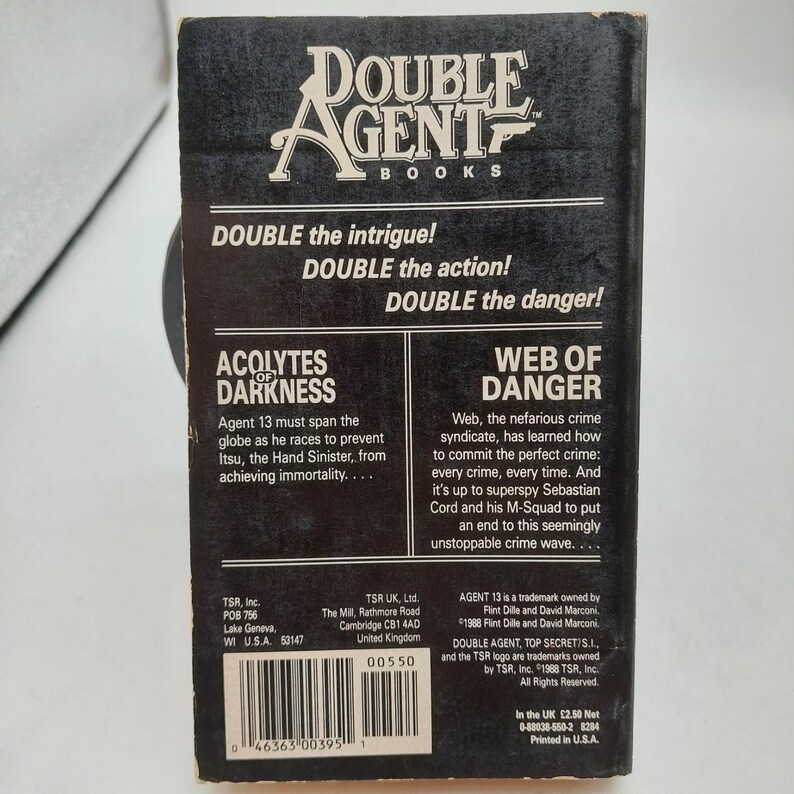 Peut inclure: Un livre de poche vintage intitul&eacute; "Double Agent Books" avec le texte "Acolytes of Darkness" et "Web of Danger". La couverture est noire avec du texte blanc. Le livre est un roman d'espionnage.