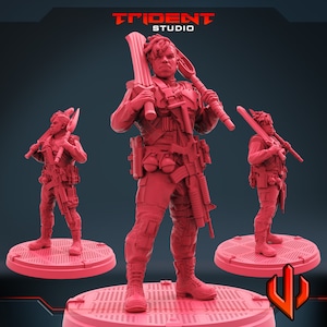 Può includere: Figurina rossa stampata in 3D di un soldato che tiene una grande lama e un fucile. La figurina è su una piattaforma circolare con un motivo a griglia. Il logo Trident Studio è visibile in alto a sinistra.