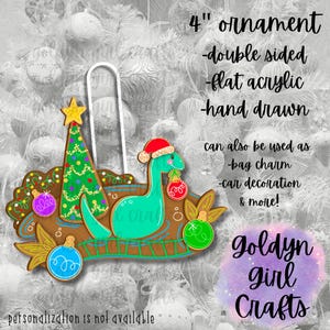 May include: A 4 inch double-sided Christmas ornament made of flat acrylic. The ornament features a green Christmas tree with colorful ornaments and a blue dinosaur wearing a red Santa hat holding a red ornament. The ornament is hand-drawn and can also be used as a bag charm, car decoration, and more. The text "goldyn girl crafts" is also visible in the image.