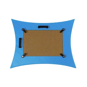 K&ouml;nnte beinhalten: R&uuml;ckseite eines blauen Bilderrahmens mit einem einzigartigen geschwungenen Design. Der Rahmen hat eine braune Kartonr&uuml;ckwand und schwarze Aufh&auml;ngungshardware. Enth&auml;lt einen S&auml;gezahnhalter und vier Drehclips.