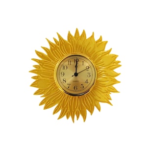 May include: A decorative wall clock shaped like a sunflower. The clock face is gold with black numerals and hands. The sunflower petals are a bright yellow color, creating a cheerful and eye-catching design.