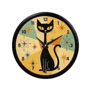 May include: A black cat-shaped wall clock with a mid-century modern design. The clock face features a geometric pattern in yellow, teal, and orange, with starburst and atomic motifs. The clock hands are black.