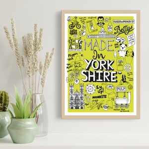 Puede incluir: Un estampado enmarcado con un fondo verde claro e ilustraciones en blanco y negro. El texto "MADE IN YORKSHIRE" se muestra de forma destacada. El estampado presenta varios dibujos y elementos de texto tem&aacute;ticos de Yorkshire.