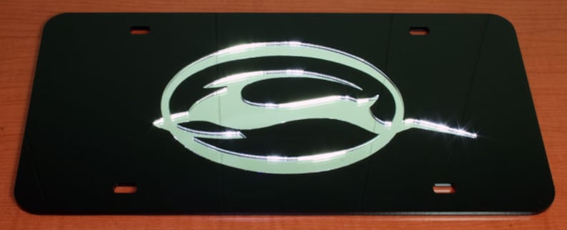 May include: Black license plate frame with a silver Chevrolet logo. The logo is a stylized bowtie with a silver finish.