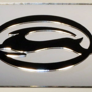 May include: A silver chrome license plate frame with a raised, three-dimensional, black Chevrolet Bowtie logo. The logo features a stylized running deer inside a circle.