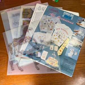 May include: A collection of craft supplies, including Shrinky Art kits and various clear plastic sheets with printed designs. The kits feature designs for t-shirts, ties, and other items. The text on the cover reads "Aleeno's All Occasions".
