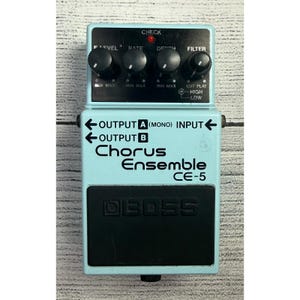 May include: A light blue Boss Chorus Ensemble CE-5 guitar effects pedal. The pedal has four black knobs, input and output jacks, and the Boss logo. The text "Chorus Ensemble CE-5" is printed on the front.
