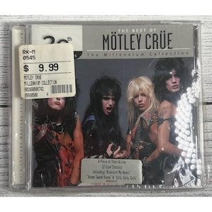 Puede incluir: Un CD de "The Best of Mötley Crüe: The Millennium Collection" con los miembros de la banda. La portada del álbum incluye el texto "A Piece of Their Action" y enumera 12 clásicos de Crüe, incluyendo "Kickstart My Heart."