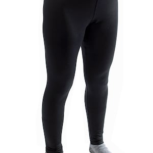 May include: Black leggings with a small silver logo at the waistband. The leggings are made of a smooth, opaque fabric. The image also shows a "Made in USA" logo.