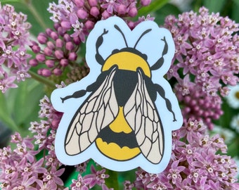 May include: A yellow and black bumblebee sticker with white wings, on a background of pink flowers.