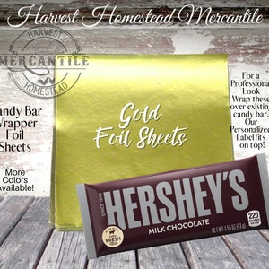 May include: Gold foil sheets for wrapping candy bars. The image shows a gold foil sheet with a Hershey's chocolate bar on top. The text "Gold Foil Sheets" is written on the foil sheet. The text "For a Professional Look Wrap these over existing candy bar. Our Personalized Label fits on top!" is written on the right side of the image.