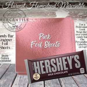 May include: Pink foil sheets for wrapping candy bars. The sheets are shown on top of a Hershey's chocolate bar. The text "Harvest Homestead Mercantile" is at the top of the image. The text "Candy Bar Wrapper Foil Sheets" is on the left side of the image. The text "Pink Foil Sheets" is in the center of the image. The text "For a Professional Look Wrap these over existing candy bar. Our Personalized Label fits on top!" is on the right side of the image.