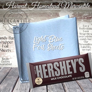 May include: Light blue candy bar wrapper foil sheets.  The foil sheets are shown wrapped around a Hershey's Milk Chocolate bar.  The text "Harvest Homestead Mercantile" is at the top of the image.