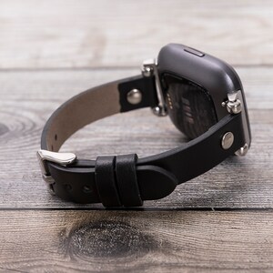 May include: Black leather watch band with silver hardware and a black smartwatch.