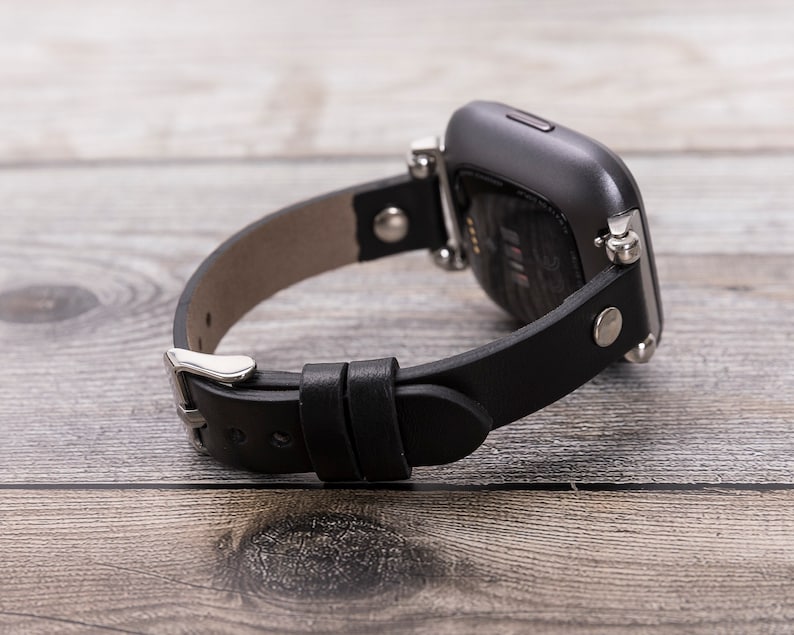 May include: Black leather watch band with silver hardware and a black smartwatch.