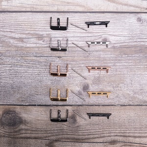 May include: Five sets of watch band adapters, each with a different finish: black, silver, rose gold, gold, and black. Each set includes a buckle and two connecting pieces.