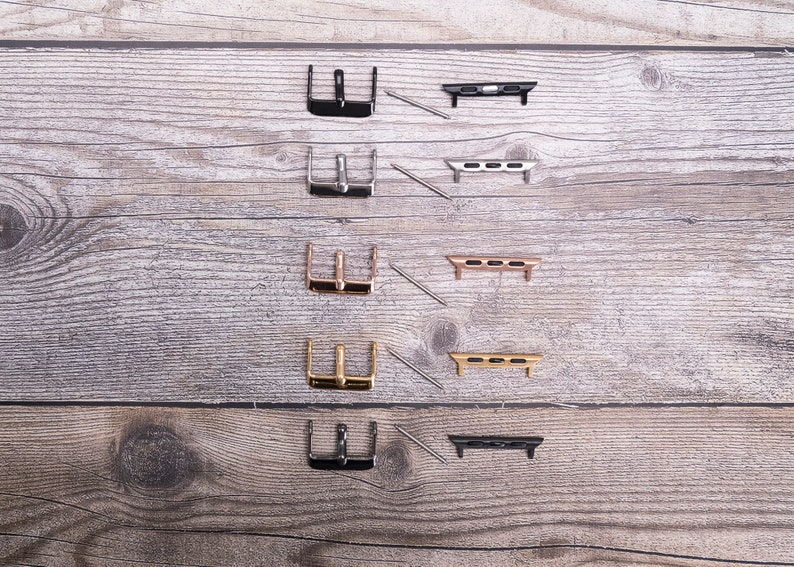 May include: Five sets of watch band adapters, each with a different finish: black, silver, rose gold, gold, and black. Each set includes a buckle and two connecting pieces.