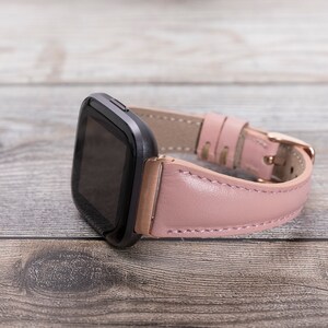 May include: A pink leather watch band with a rose gold buckle and a black smartwatch face.