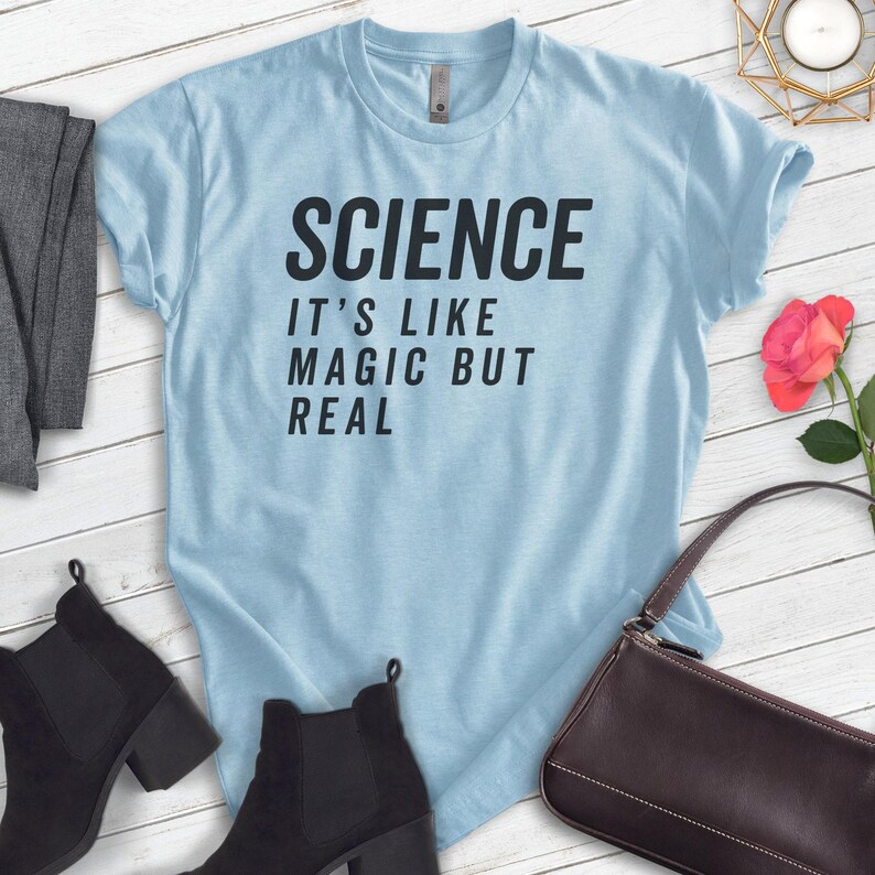 May include: A light blue t-shirt with the text "SCIENCE IT'S LIKE MAGIC BUT REAL" printed in black.