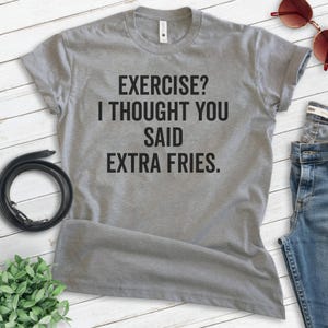 May include: Gray t-shirt with the text "EXERCISE? I THOUGHT YOU SAID EXTRA FRIES."