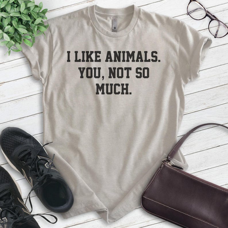 K&ouml;nnte beinhalten: Ein hellgraues T-Shirt mit dem Text "Ich mag Tiere. Du, nicht so sehr." in Schwarz gedruckt.