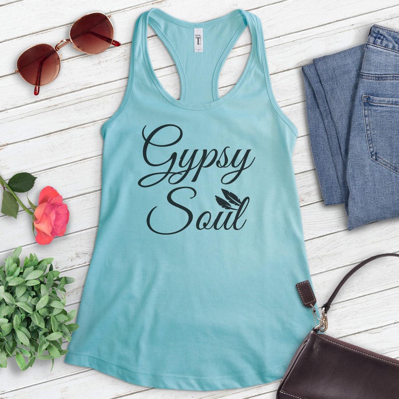 Może przedstawiać: Jasno błękitny top na ramiączkach z napisem "Gypsy Soul" w czarnych literach. Tekst jest napisany kursywą i zawiera dwa małe wzory pi&oacute;r.