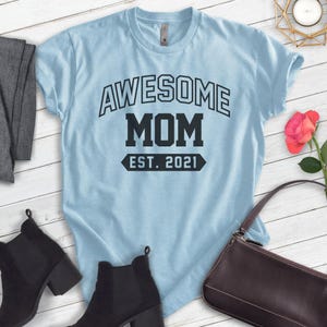 Peut inclure: T-shirt bleu clair avec le texte "Awesome Mom Est. 2021" en noir.