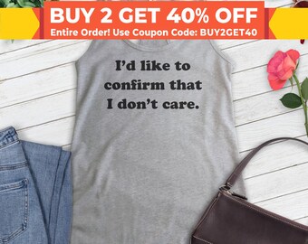 May include: Gray tank top with the text "I'd like to confirm that I don't care."  The tank top is on a white surface with a pair of sunglasses, a purse, and a rose.