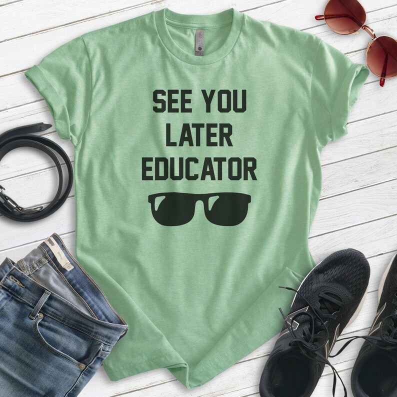 May include: A light green t-shirt with the text "See You Later Educator" in black lettering and a pair of black sunglasses.