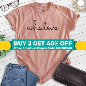 May include: A light pink t-shirt with the word "whatevs" in a black script. The shirt is paired with blue jeans and a black purse. A banner across the bottom reads "BUY 2 GET 40% OFF".