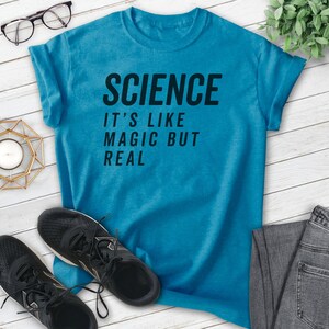 May include: A turquoise blue t-shirt with the text "SCIENCE IT'S LIKE MAGIC BUT REAL" printed in black.