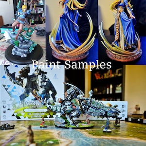 May include: Painted miniatures of characters and creatures from the Horizon Zero Dawn board game. The miniatures include a female character in a blue dress, a male character with a bow and arrow, a large mechanical creature, and a smaller creature. The game box is visible in the background.